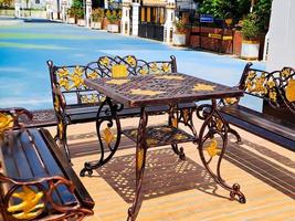 brown gold iron carving bench with arabic architecture in madiun indonesia park, sunny weather. photo