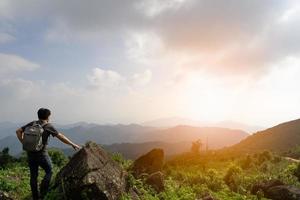 A wide shot of sian man with his backpack is travel alone and look at far a way, nature travel and environment concept, copy space for individual text photo