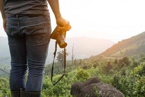 close up shot of Asian man catching camera travel alone at mountain and look at far a way adventure alone, nature travel and environment concept computer sunrise light, copy space for individual text photo