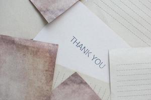 thank you message and envelope on wooden table photo