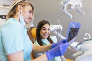 el dentista le está explicando al paciente el escaneo de la mandíbula. . usar máscaras protectoras respetando las medidas de seguridad prescritas con respecto a la pandemia de covid-19. foto