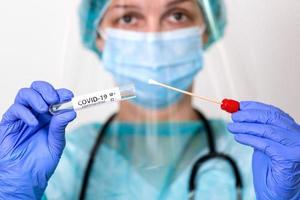 atención médica con covid-19, kit de recolección de hisopos de coronavirus, uso de guantes de máscara de traje protector de ppe, tubo de ensayo para tomar muestras de muestras de pacientes op np, proceso de protocolo de prueba de adn pcr foto