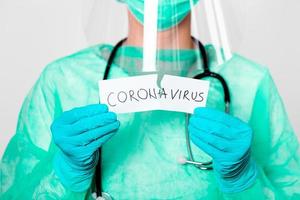 Concept of coronavirus quarantine. Covid  19. Novel coronavirus  2019-nCoV .Doctor with a stethoscope Tear the paper with the word coronavirus. photo
