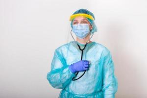 female doctor wearing PPE protection suite for fighting and stop Spread of Covid-19 coronavirus with white background and covid-19 outbreak concept. Medical worker in protective gear with stethoscope photo