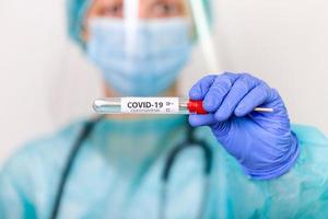 Medical healthcare holding COVID-19 , Coronavirus swab collection kit, wearing PPE protective suit mask gloves, test tube for taking OP NP patient specimen sample,PCR DNA testing protocol process photo