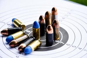 9mm pistol gun bullets on shooting target paper for training and practising the shooting sport, soft and selective focus. photo