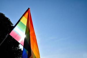 Bandera del arco iris lgbt ondeando y contra el cielo azul en la tarde del día, enfoque suave y selectivo, concepto para la celebración lgbtq en el mes del orgullo en todo el mundo. foto