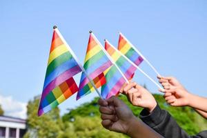 Rainbow flags, LGBT symbol, holding in hands, concept for LGBT community celebration in pride month, June, 2023, around the world. photo