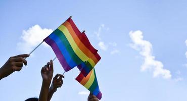 banderas del arco iris, símbolo lgbt, tomados de la mano, concepto para la celebración de la comunidad lgbt en el mes del orgullo, junio de 2023, en todo el mundo. foto
