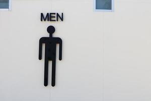 Man symbol and word men on white wall concrete of toilet. photo