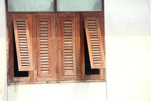 Rectangle shape wood brown window row with white wall. Some window opening and sunlight on window. photo