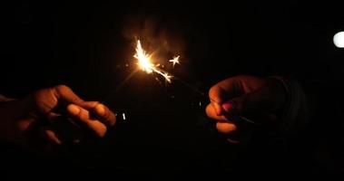 Close up, Female hands holding fireworks burning sparkler in new year's party night, beautiful sparkly with flare on night scene video