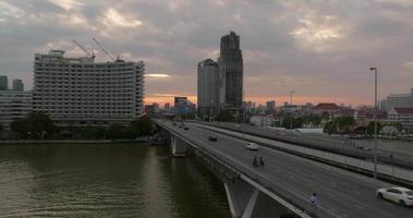 luftaufnahme der taksin-brücke und des sathorn road-geschäftszentrums mit transport über den chao phraya-fluss bei sonnenaufgang, bangkok, thailand video