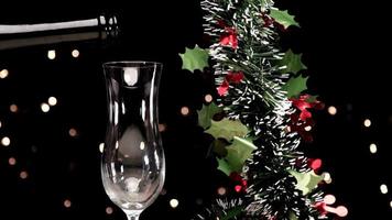 Pouring Champagne for Christmas Eve dinner with lights and garland decoration at slow motion video