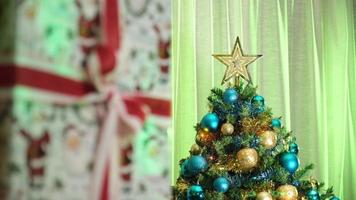 regalo de Navidad y pino decorado en una acogedora sala de estar de invierno durante la noche de Nochebuena. luces de colores en movimiento.