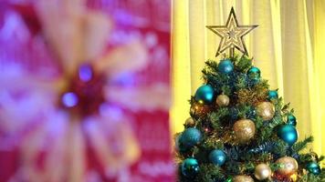 presente de natal e pinheiro decorado em uma aconchegante sala de estar em casa de inverno durante a noite de véspera de natal. luzes coloridas em movimento. video