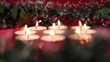 bougies de noël sur fond rouge et décoration de guirlande de noël pour la célébration religieuse de vacances video