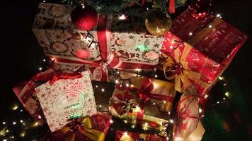 presentes coloridos sob o pinheiro na noite de véspera de natal em uma aconchegante sala de estar em casa de inverno video