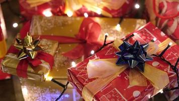 regalos coloridos bajo el pino en la noche de Nochebuena en una acogedora sala de estar en casa de invierno video