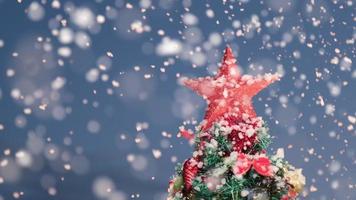 neve no pinheiro decorado de natal durante a noite de véspera de natal. inverno nevando em câmera lenta. video