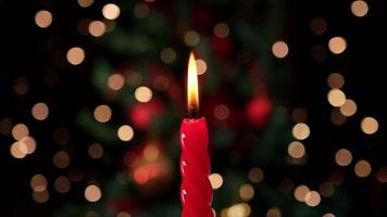 luz de vela vermelha para celebração de natal, fundo de natal. luz de velas de cera. video