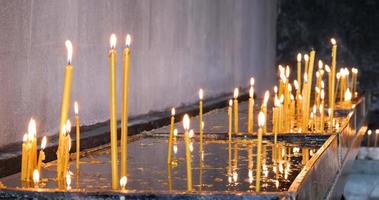 Candles in the church. Religion and commemorations. Candles burning. Detail shot. Close-up. Cinematic shot.