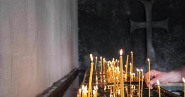 Candles in the church. Religion and commemorations. Candles burning. Detail shot. Close-up. Cinematic shot. Orthodox cross. Faith. video