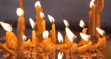 Kerzen in der Kirche. Religion und Gedenken. Kerzen brennen. Detailaufnahme. Nahansicht. filmische Aufnahme. video