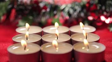 luces de velas de navidad sobre fondo rojo y decoración de guirnaldas de navidad para la celebración religiosa navideña video