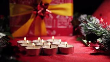 Christmas candle lights and gift on red background decoration video