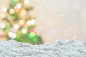 Empty white snow with blur Christmas tree with bokeh light background photo