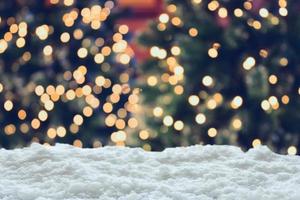 Empty white snow with blur Christmas tree with bokeh light background photo