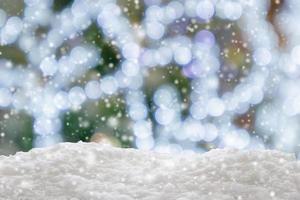 Empty white snow with blur Christmas tree with bokeh light background photo