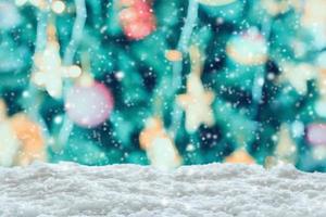 Empty white snow with blur Christmas tree with bokeh light background photo