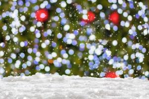 Empty white snow with blur Christmas tree with bokeh light background photo