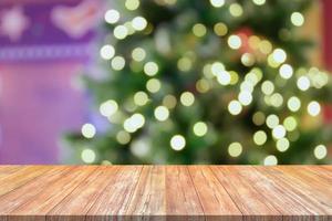 Empty wood table top with blur Christmas tree with bokeh light background photo