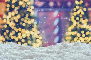 Empty white snow with blur Christmas tree with bokeh light background photo