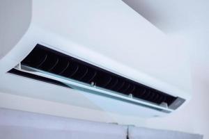 Air conditioner on white wall room interior background photo