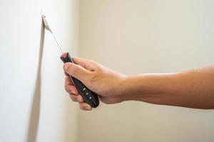 Man repairing crack white wall with spatula photo