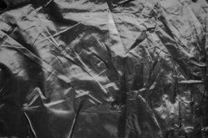 transparent plastic bag wrap overlay texture on black background photo