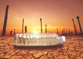 concept of water scarcity Drought due to global warming. Water bottles placed in drought and broken soil areas photo