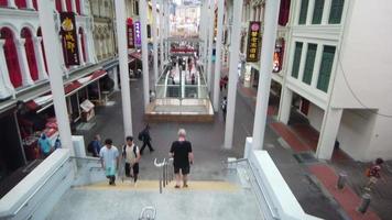 An open mall with tall columns, pedestrians walking by video