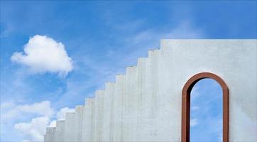 pared de cemento y escalera con marco de ventana de madera, arquitectura loft edificio fondo de pared de hormigón gris con arcos toscanos puerta de madera marrón contra el cielo azul y las nubes, concepto exterior mínimo foto