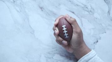 Holding a small american football ball, pigskin video