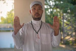 Young asian muslim man praying on sunset,Ramadan festival concept photo