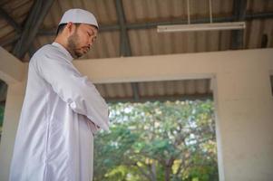 joven musulmán asiático rezando al atardecer, concepto de festival de ramadán foto