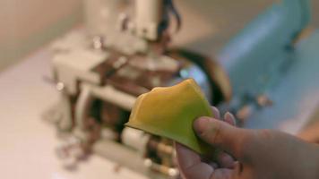 machine à coudre dans un atelier de cuir en action avec des mains travaillant sur des détails en cuir pour chaussures. un plan macro sur les mains des femmes avec une machine à coudre à l'usine de chaussures video