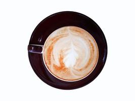 Top view of cup of art cappuccino or latte coffee isolated on white background with clipping path and make selection. Flat lay of hot drinking in brown glass and bottom plate. Food design concept. photo