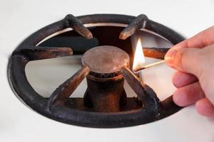 A man lights a gas stove with a match. vintage gas burner without flame. No gas. photo