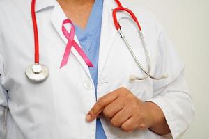 Asian woman doctor with pink ribbon, World Breast Cancer Day at October. photo